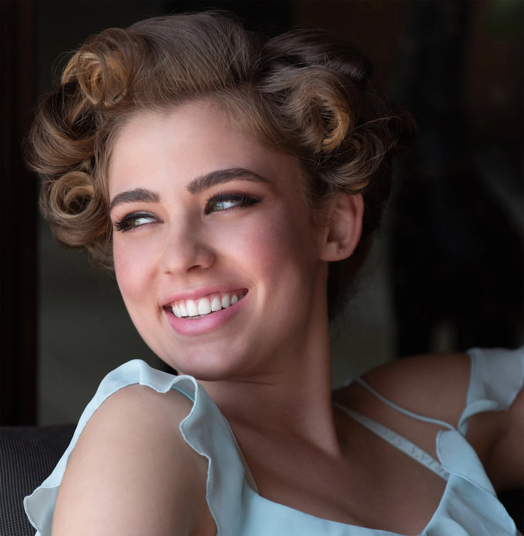 Featured portrait retouching of a smiling woman with a vintage curled hairstyle